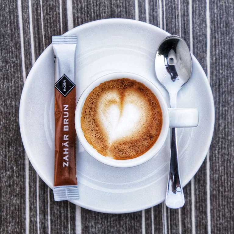 Flat lay, a top-down shot of a cup of espresso, with a heart-shaped foam art