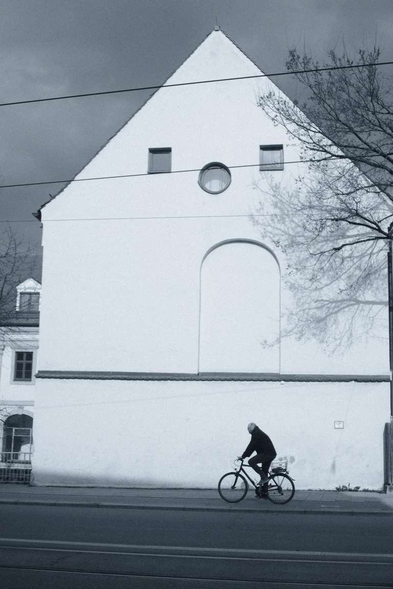 A cyclist driving in front of a building